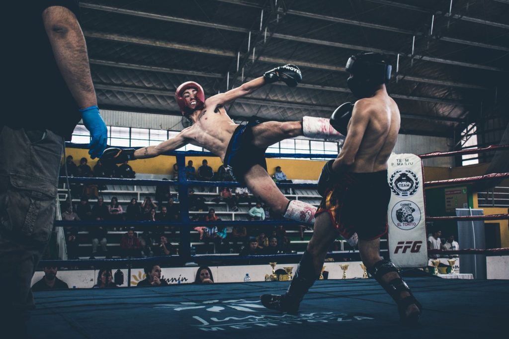 Combattant qui frappe un low kick en muay-thaï