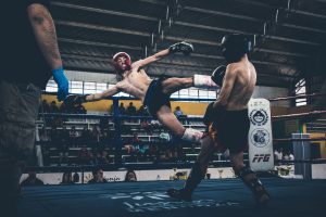 Combattant qui frappe un low kick en muay-thaï