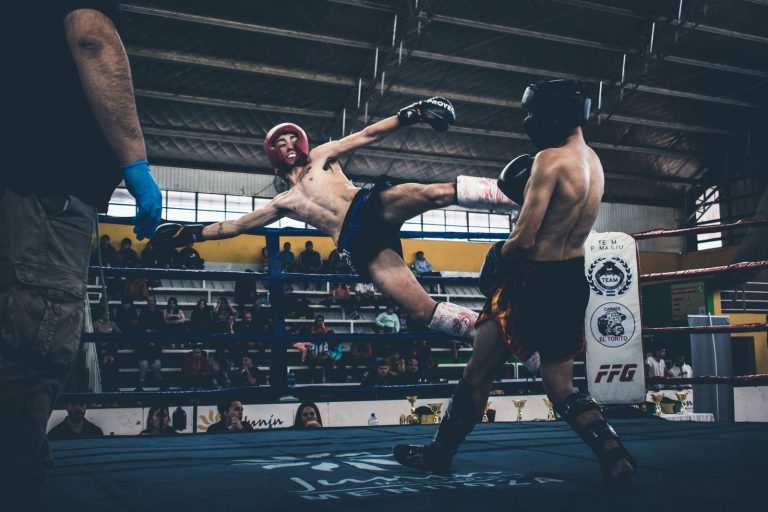 Combattant qui frappe un low kick en muay-thaï
