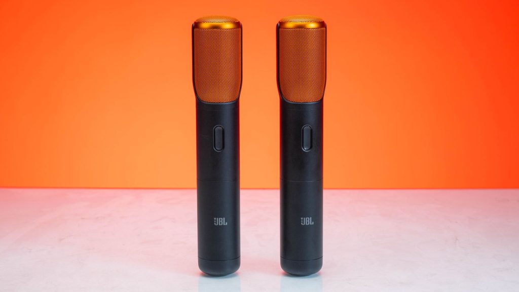 Stylish wireless microphones set against a bold orange backdrop, perfect for audio tech themes.