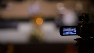 Video camera capturing an event with blurred bokeh background night scene.
