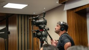 Cameraman operating professional video cameras during an indoor event. Perfect for media and broadcasting themes.