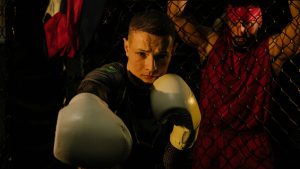 Intense boxing scene with a focused fighter and trainer in a dimly lit ring.