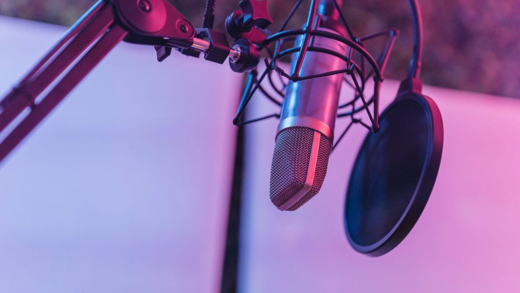 A close-up view of a microphone in a vibrant studio environment, ideal for podcasts and voice recording.