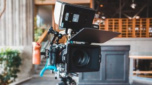 Close-up of a modern camera setup with a Rode monitor in a studio setting.