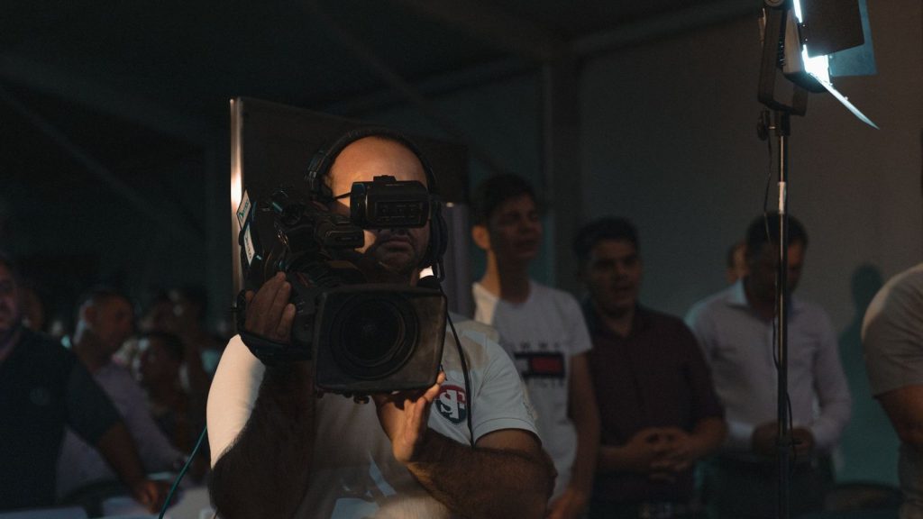 A cameraman capturing a religious gathering inside a Romanian church.