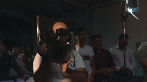 A cameraman capturing a religious gathering inside a Romanian church.