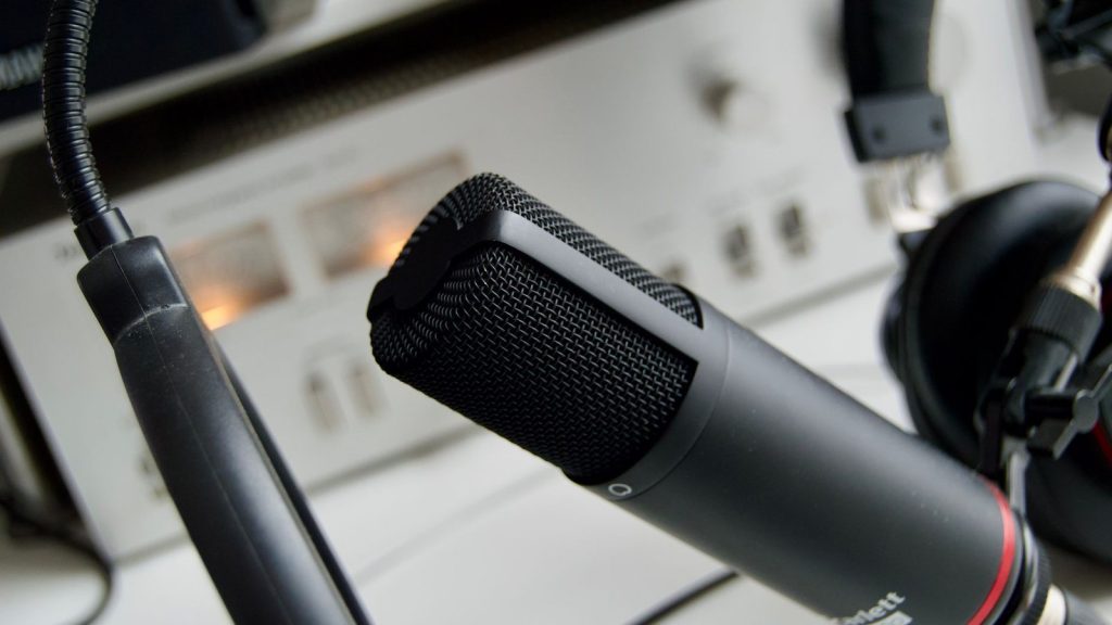 Close-up shot of a microphone in a studio setting, ideal for audio recording.