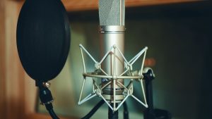 Close-up of a studio microphone with pop filter, perfect for recording.