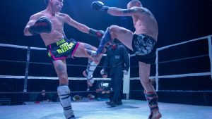 Two male kickboxers engage in an intense fight, showcasing skill and strength.