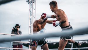 An intense outdoor boxing match capturing a powerful punch between two fighters.