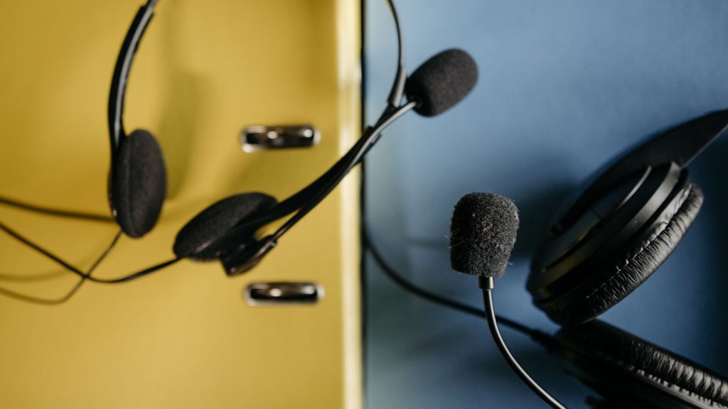 Close-up of headphones with attached microphones on a vibrant yellow and blue background, perfect for tech-related conte