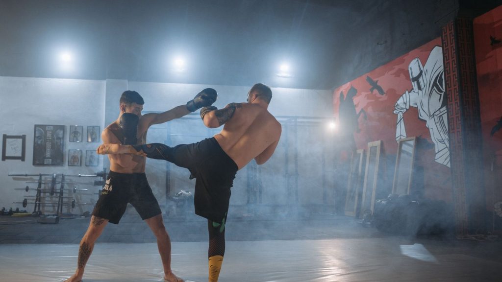 Two male fighters engaged in intense martial arts training, showcasing strength and technique.