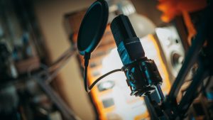 Close-up of a microphone with pop filter in a recording studio, perfect for music production visuals.
