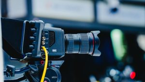 Close-up shot of a professional 6K video camera mounted on a tripod, ideal for filming and video production.
