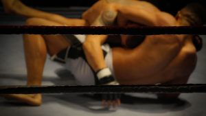 Two athletes engaged in a dynamic wrestling match within the ring.