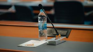 Conference table setup in Thailand with bottled water, microphone, and documents. Ideal for business themes.