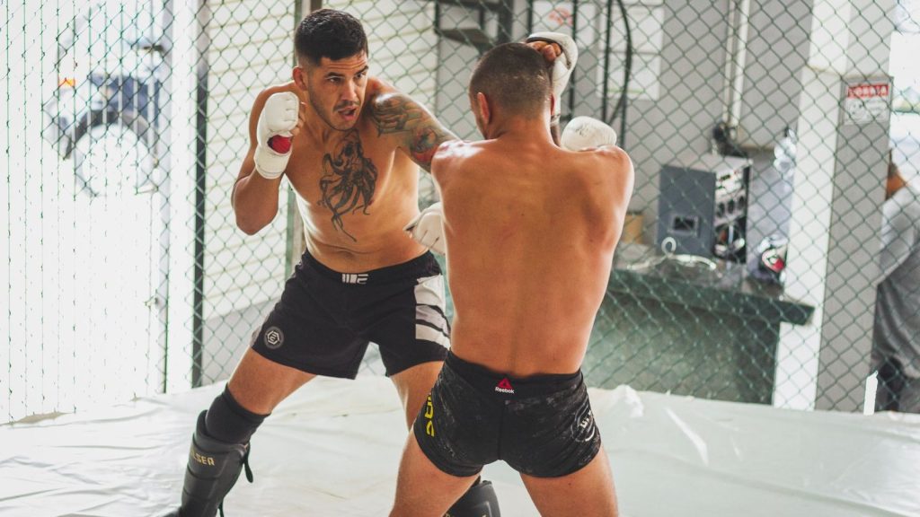 MMA sparring between two athletes in a gym setting, showcasing skill and intensity.