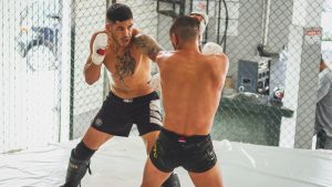 MMA sparring between two athletes in a gym setting, showcasing skill and intensity.