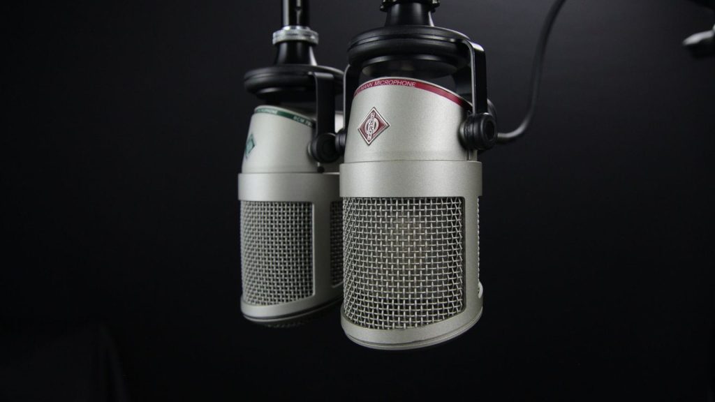 Close-up of two professional microphones in a recording studio, ideal for podcasts and music production.