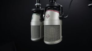 Close-up of two professional microphones in a recording studio, ideal for podcasts and music production.
