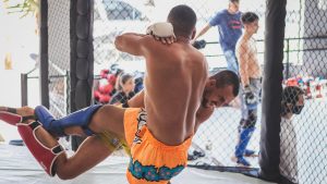 Intense MMA fighters in action during a sparring session inside a training cage.