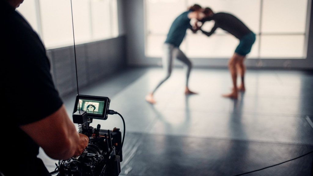 Capturing martial arts practice with professional filming equipment in a gym setting.