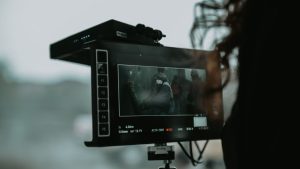A close-up of professional filming equipment capturing a scene outdoors.